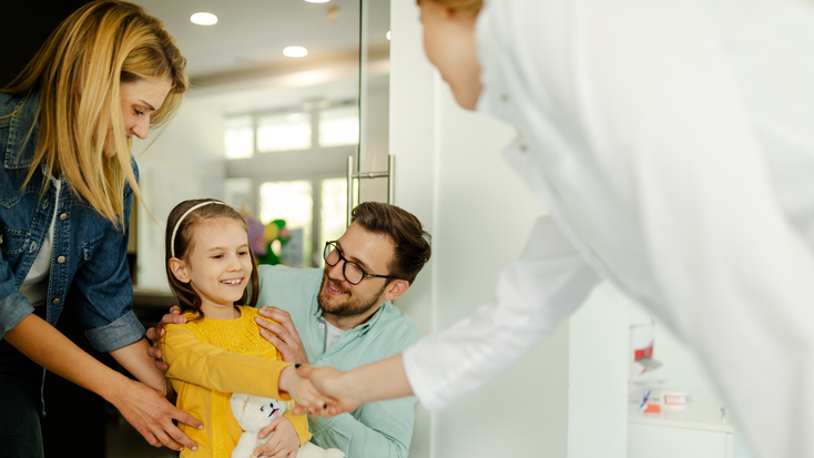 Parents and child girl in meeting with doctor