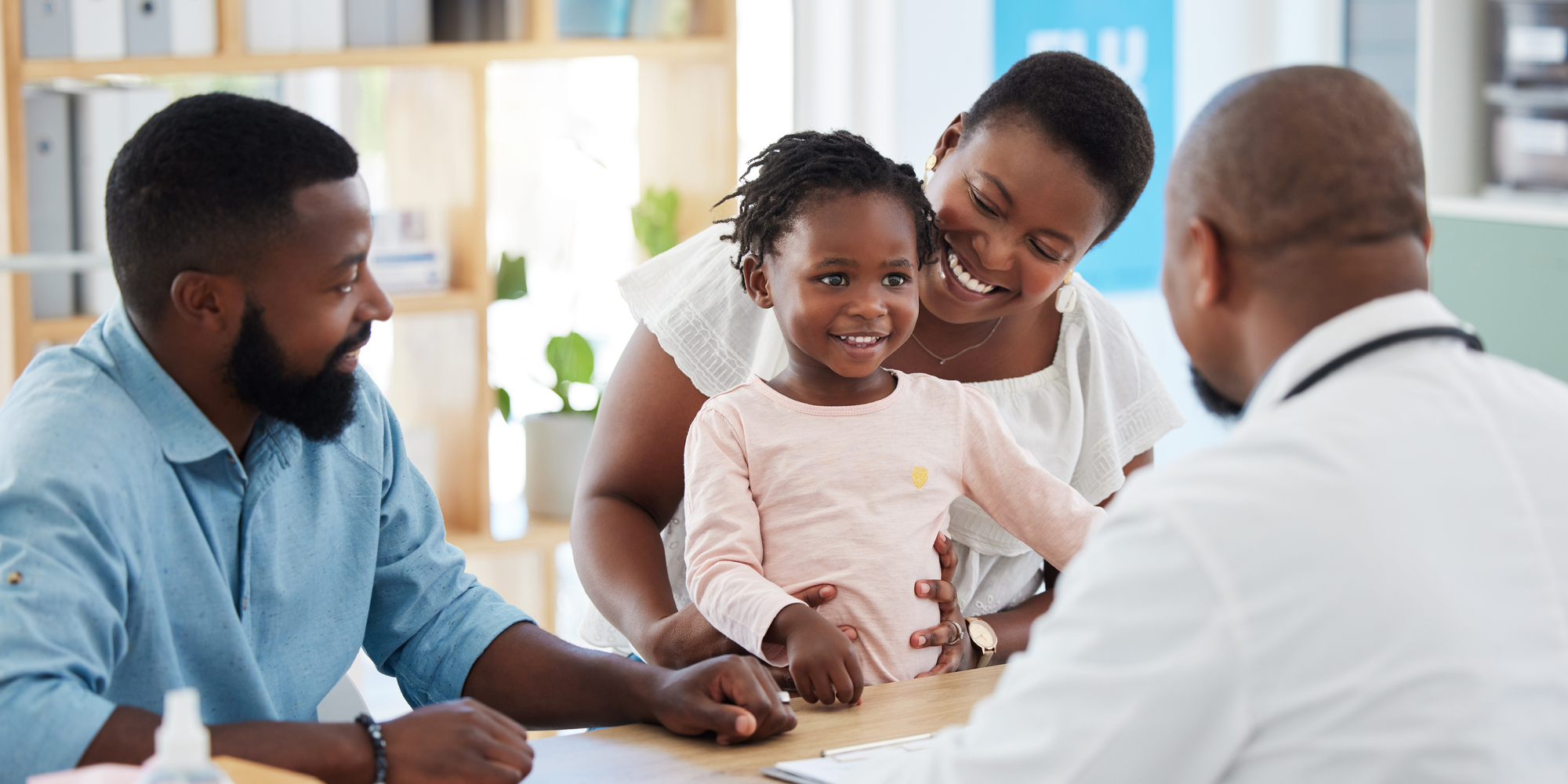 Pediatric physician talking with little girl and parents 