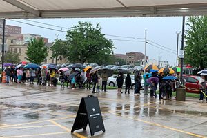 People stand in line in parking lot