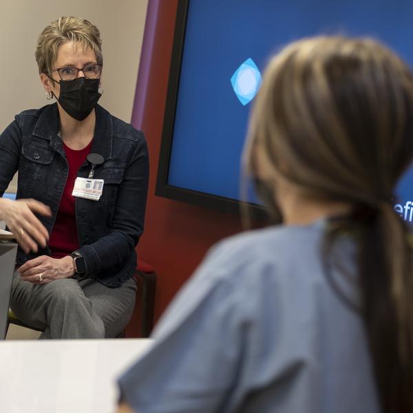 Instructor speaks with nurse in debriefing room