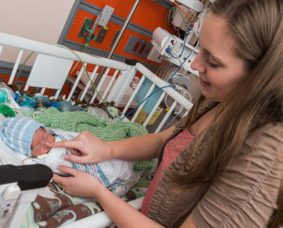 A mother spends time with her premature infant in the NICU in 2017. Parents are encouraged to be active in their babies’ care.