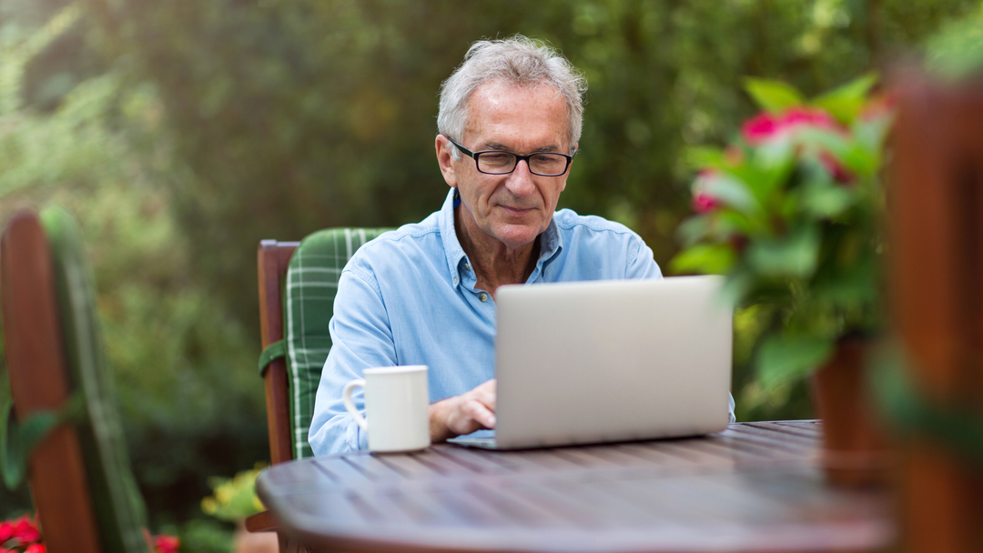 Older gentleman sitting at table with laptop