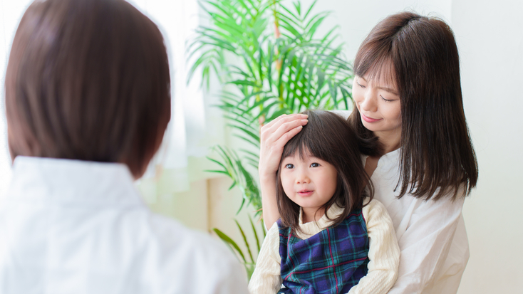 little girl being examined by doctor