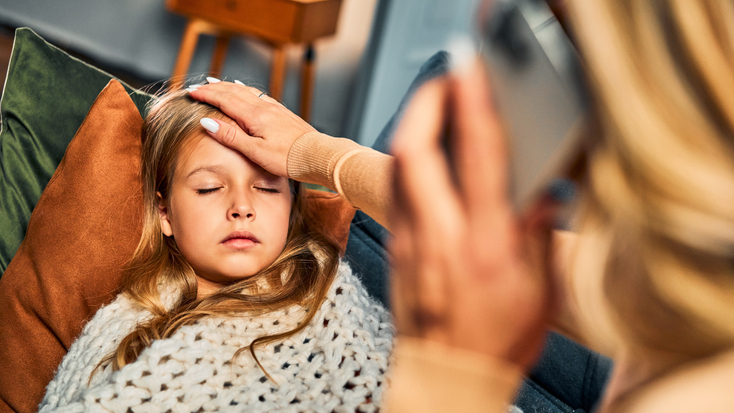 Mother checking girl's forehead for a fever
