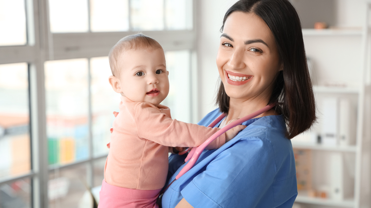 Portrait of female pediatrician with little baby in clinic