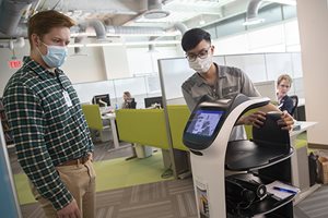 Student interns work with robot