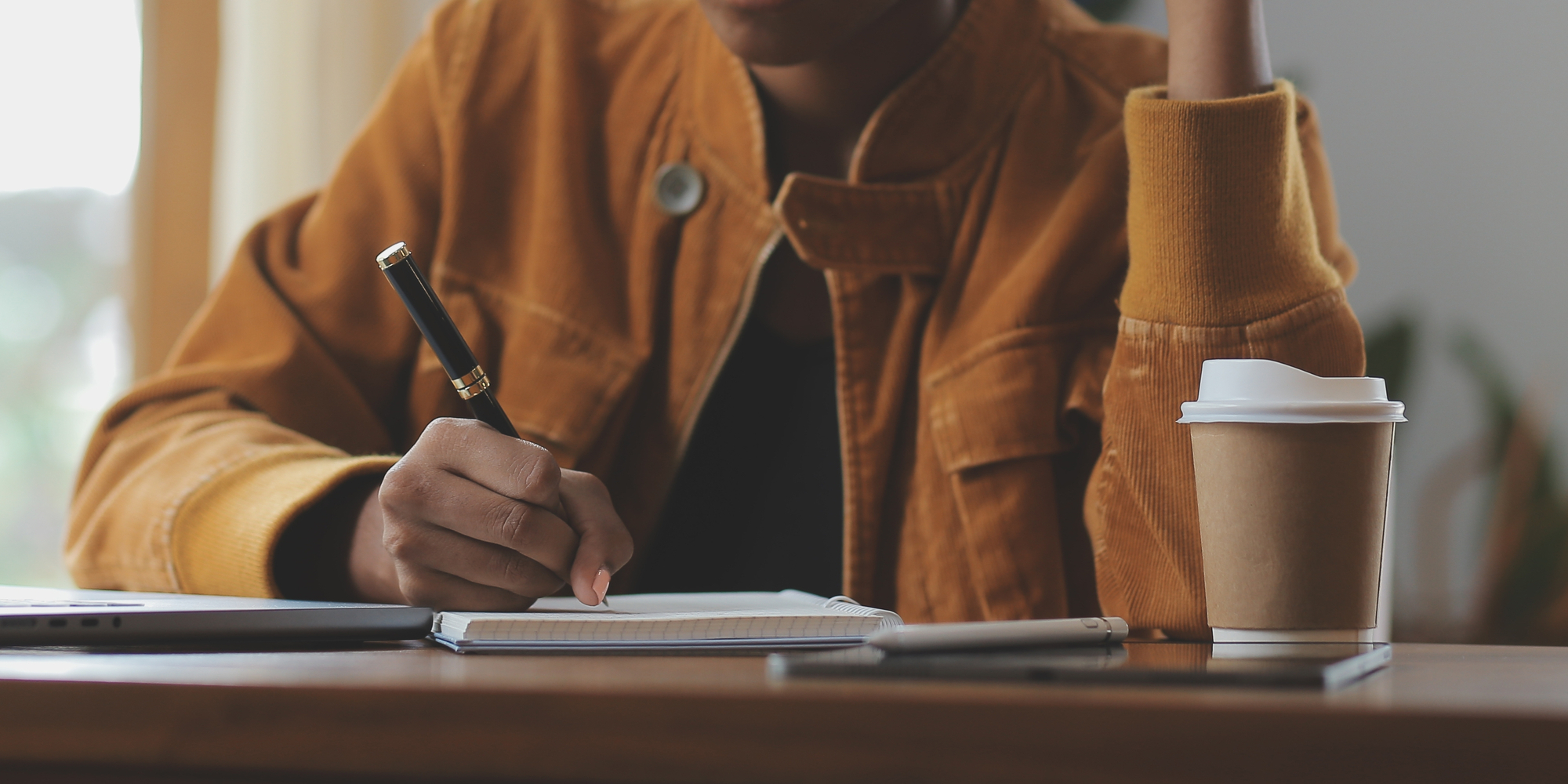 Hispanic girl using laptop and drinking coffee