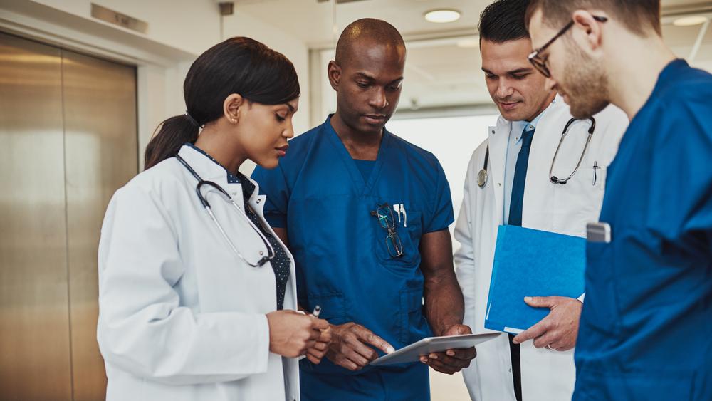 Team of doctors looking at a tablet