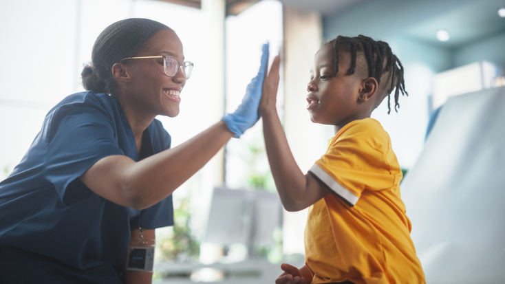 young boy high five pediatric nurse