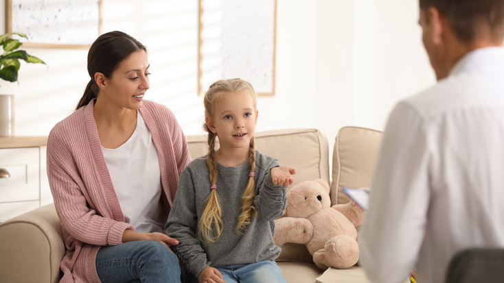 mother and her young daughter attending a child psychology session with a therapist in a comfortable office.