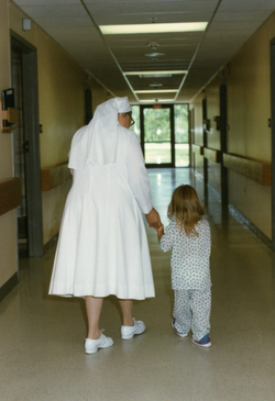 1988 Sister Sniceta walking with a child in Escanaba