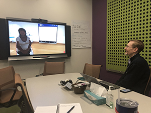 Dr Bond seated in teleconference room