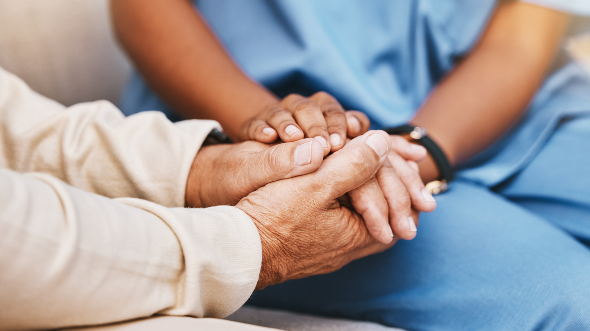 Close up of nurse holding patients hands