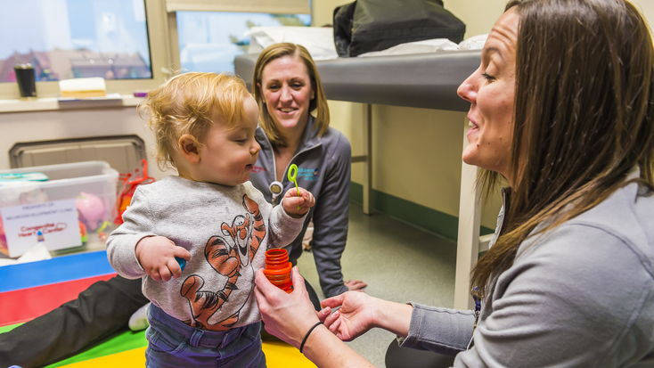 Nurse blowing bubbles with toddler