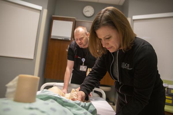 OSF clinical educator prepares manikin trainer.