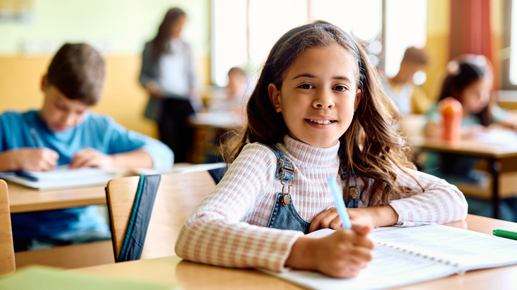 Girl Sitting at Desk in School