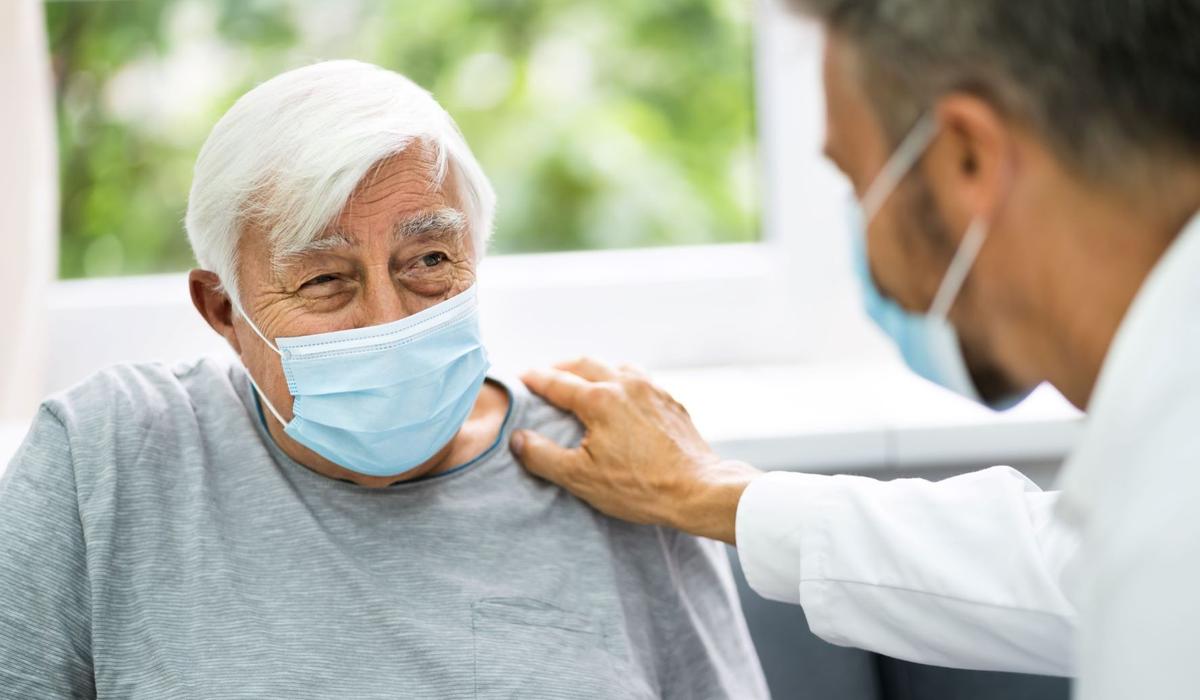 Senior man with face mask and doctor