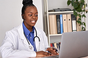 Physician speaking to laptop
