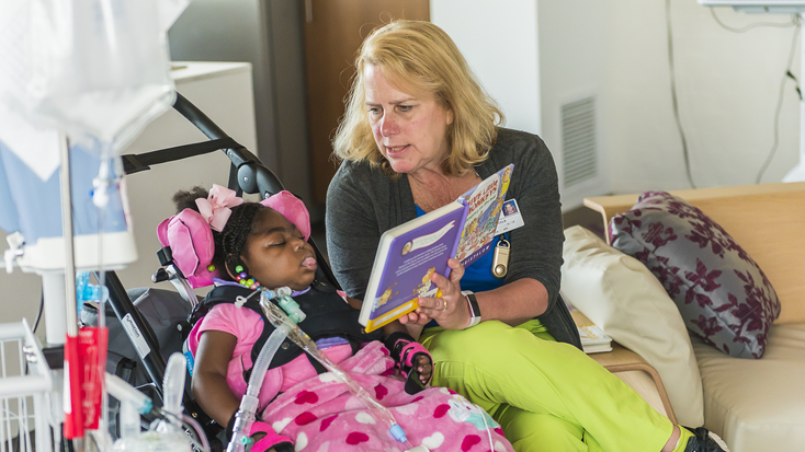 OSF Children's Hospital of Illinois care taker reading to patient