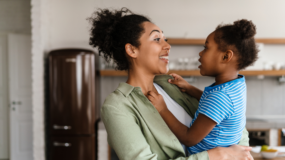African-American mother smiling and holding her daught