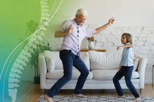 grandfather and grandson dance in the living room with an image of a human spine digitized next to them