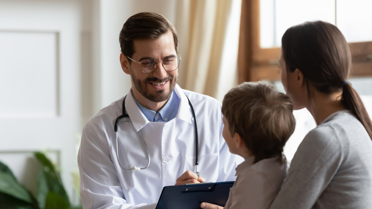 smiling male pediatrician white medical uniform