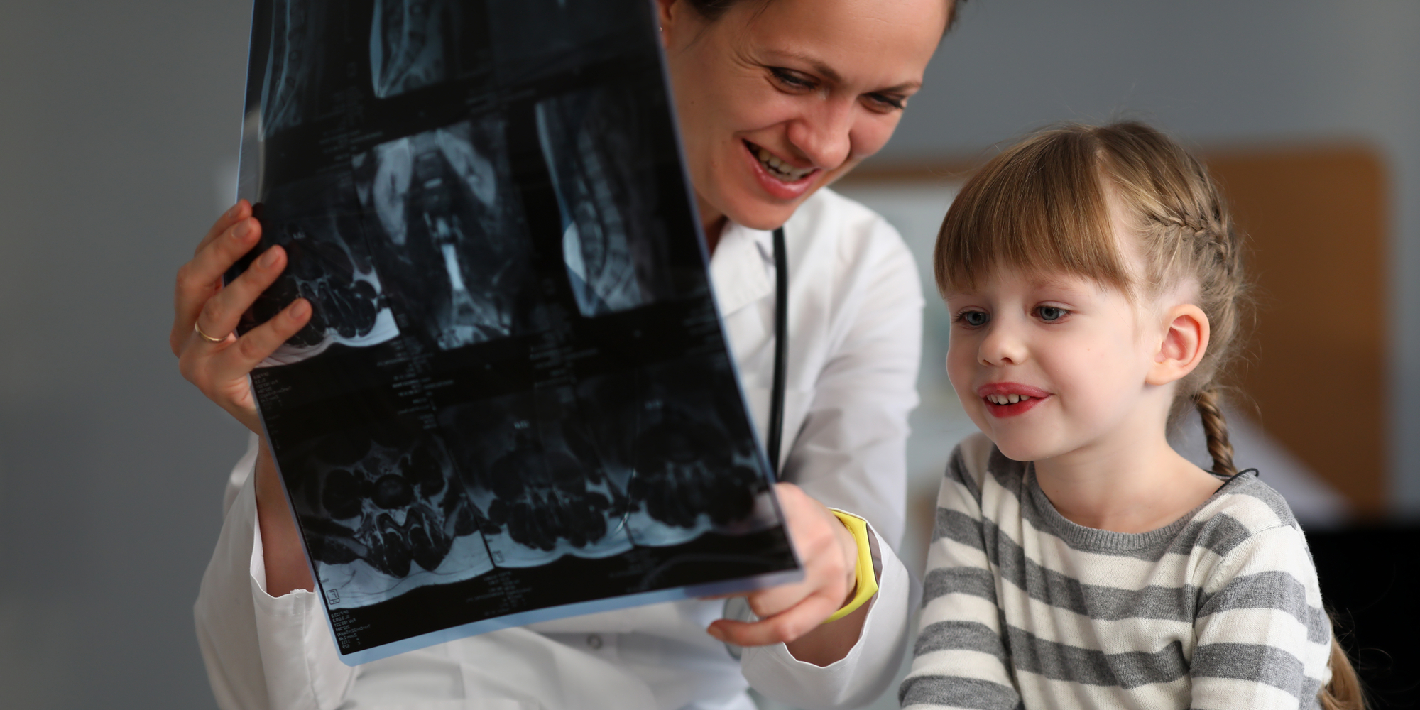 female doctor showing x-ray to little girl