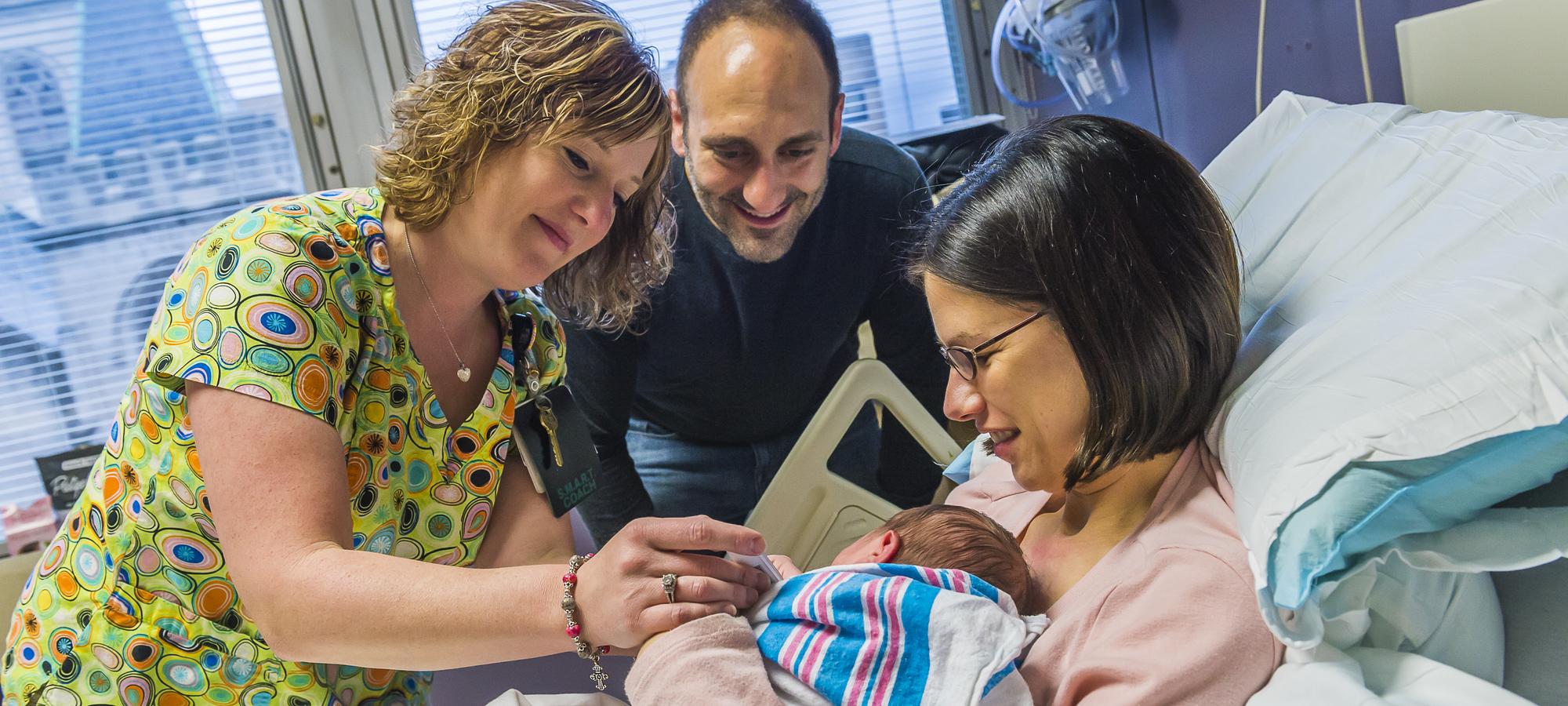 Parents with newborn baby and nurse