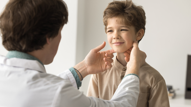 Young man otolaryngologist in white coat examine lymph touches nodes of little kid patient.