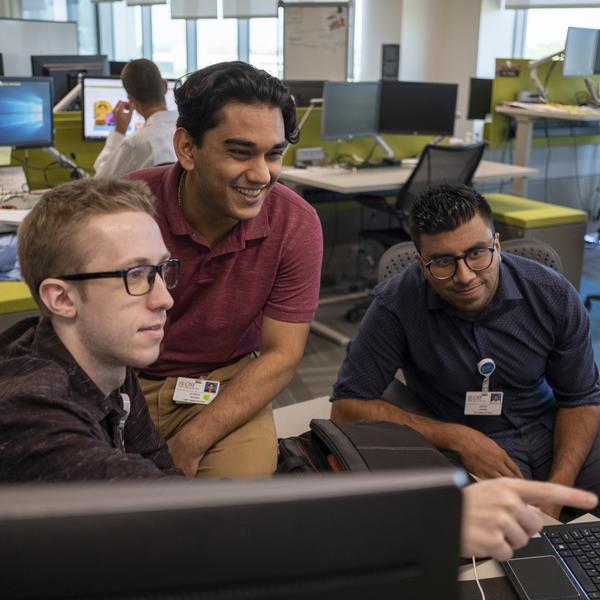 Three interns work together at computer