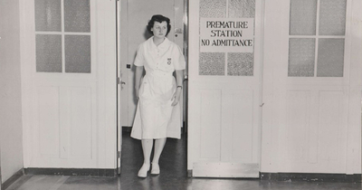 A black and white 1940s-era photograph of a nurse in a white uniform walking through a doorway labeled 'Premature Station - No Admittance.'